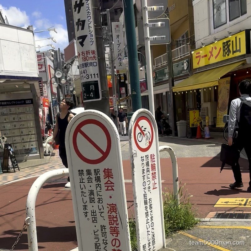 駅前。黄色い「ラーメン豚山」の看板が見える