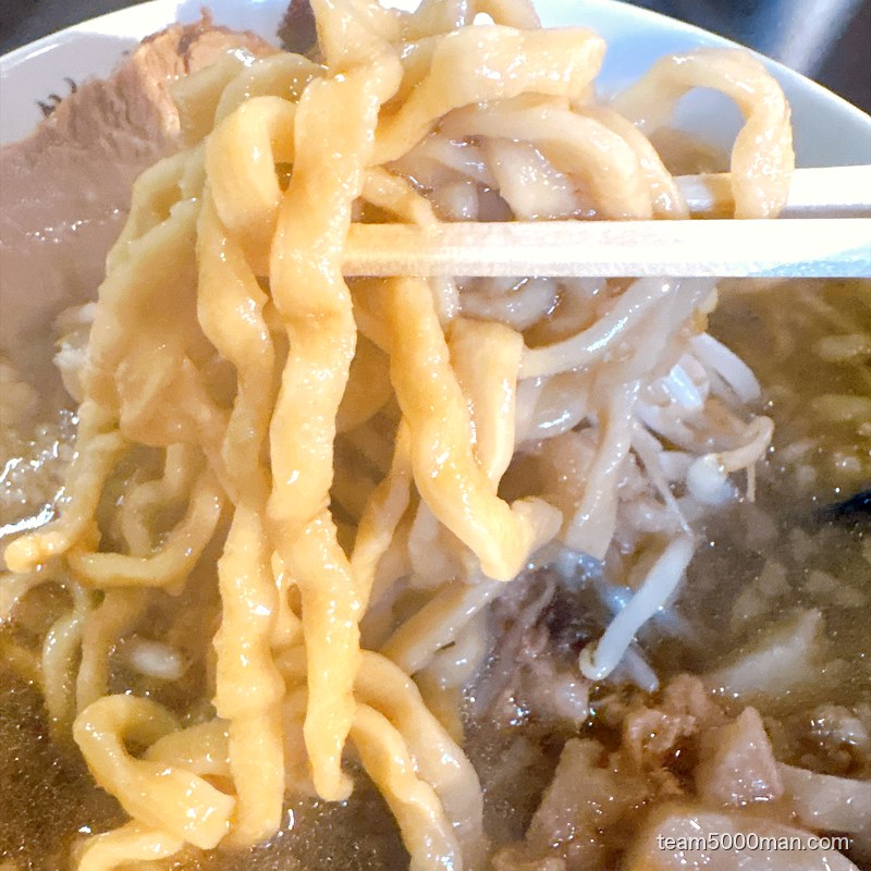 箸で持ち上げたマジックの道の固めの極太麺
