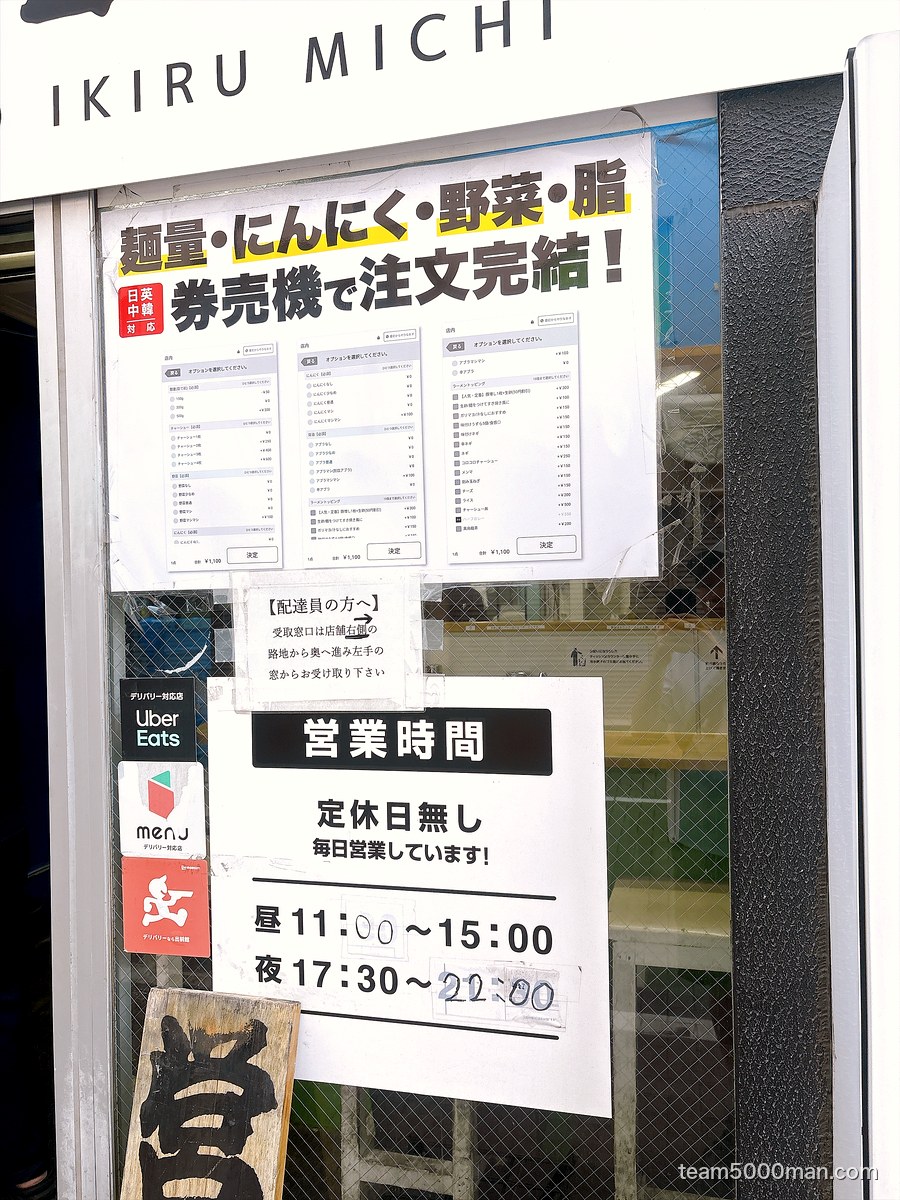 「麺量・にんにく・野菜・脂 券売機で注文完結!」の店頭掲示と営業時間(定休日無し/昼11:00〜15:00・夜17:30〜22:00)
