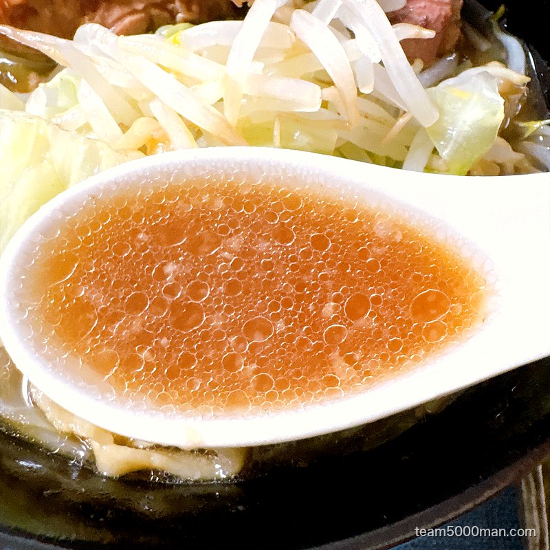 ラーメンマルキの非乳化スープをレンゲで。透き通った琥珀色をしている