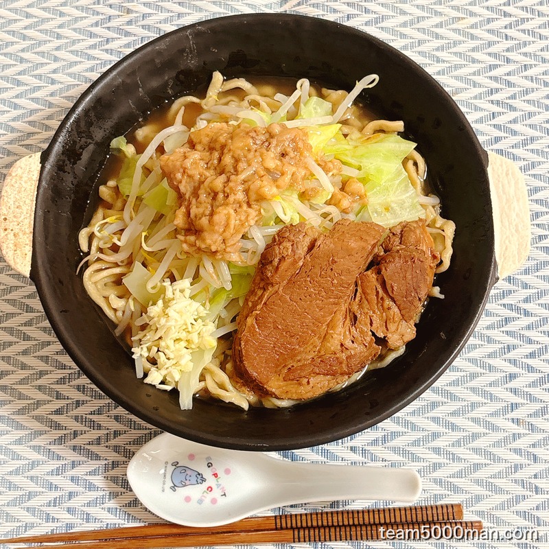俺の生きる道 夢のラーメンの完成した丼を真上から見たところ。キャベツともやしの上に大判チャーシューと味付け脂