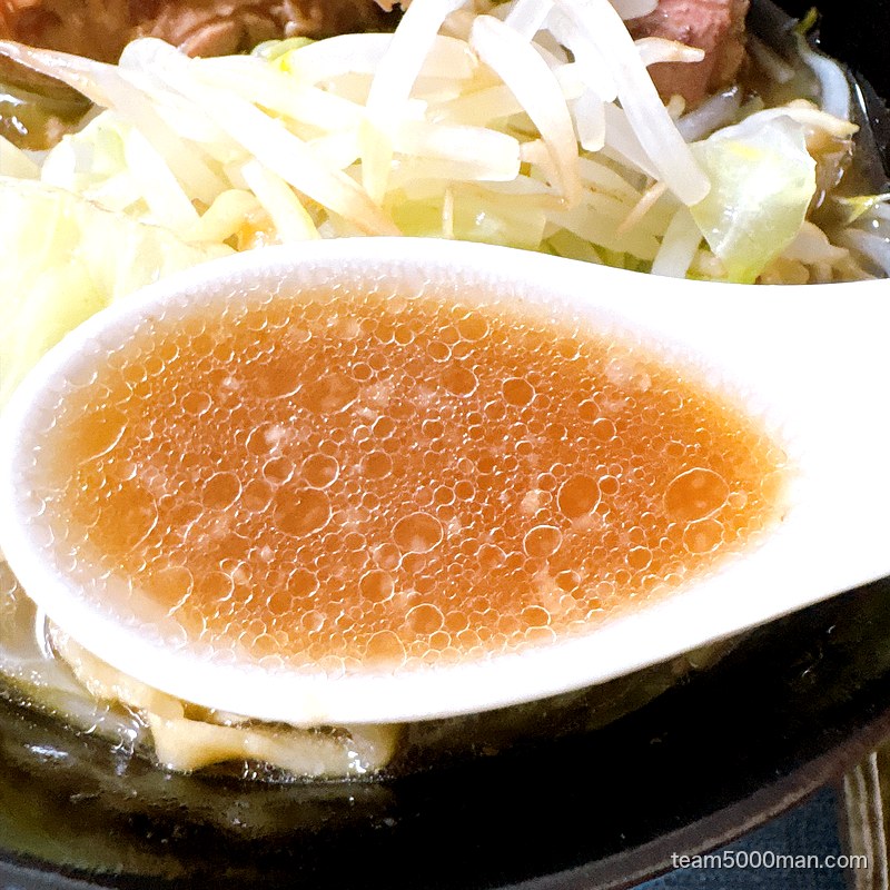 ラーメンマルキの非乳化スープをレンゲで。透き通った琥珀色をしている