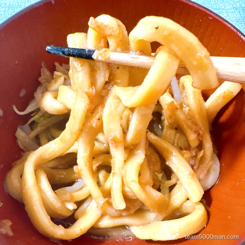 卵を絡めたえびラーメンの麺を持ち上げたところ