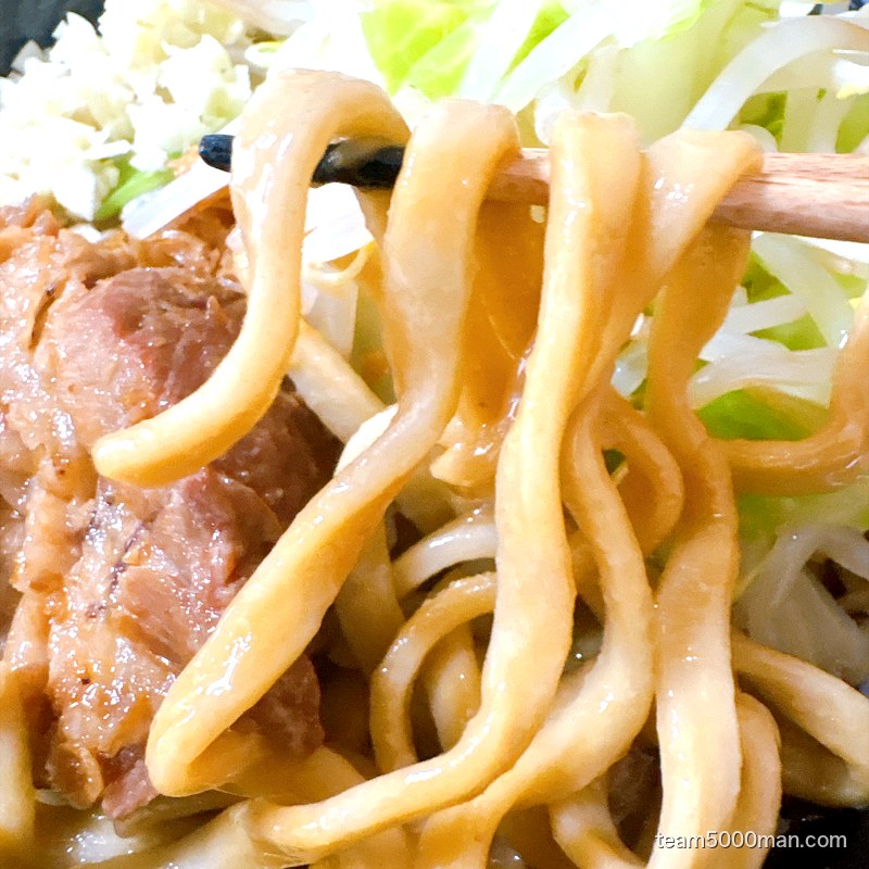 えびラーメンの極太ストレート麺を箸で持ち上げたところ