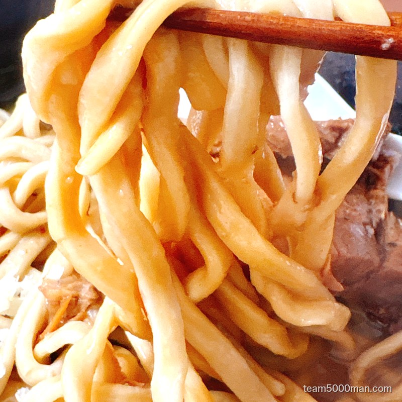 ラーメンゼンゼンの超極太麺を箸で持ち上げたところ。低加水のバキボキ麺