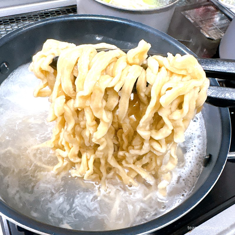 豚ノヴァ 汁なし 茹でている太麺を持ち上げたところ