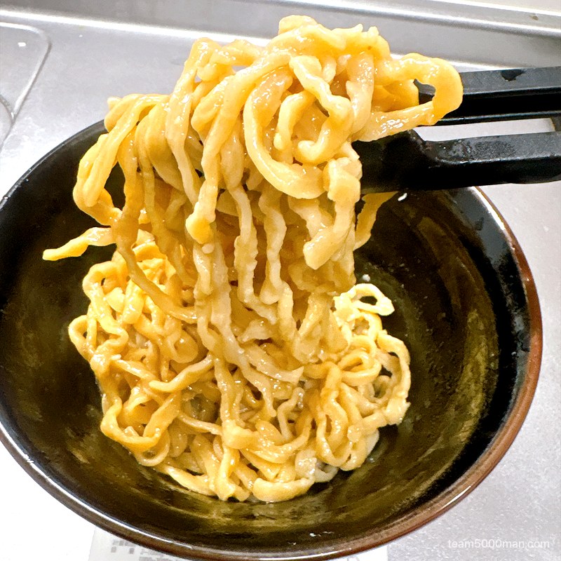 豚ノヴァ 汁なし タレを絡めた太麺を箸で持ち上げたところ
