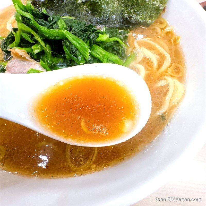 町田家 本店のスープをレンゲですくったところ