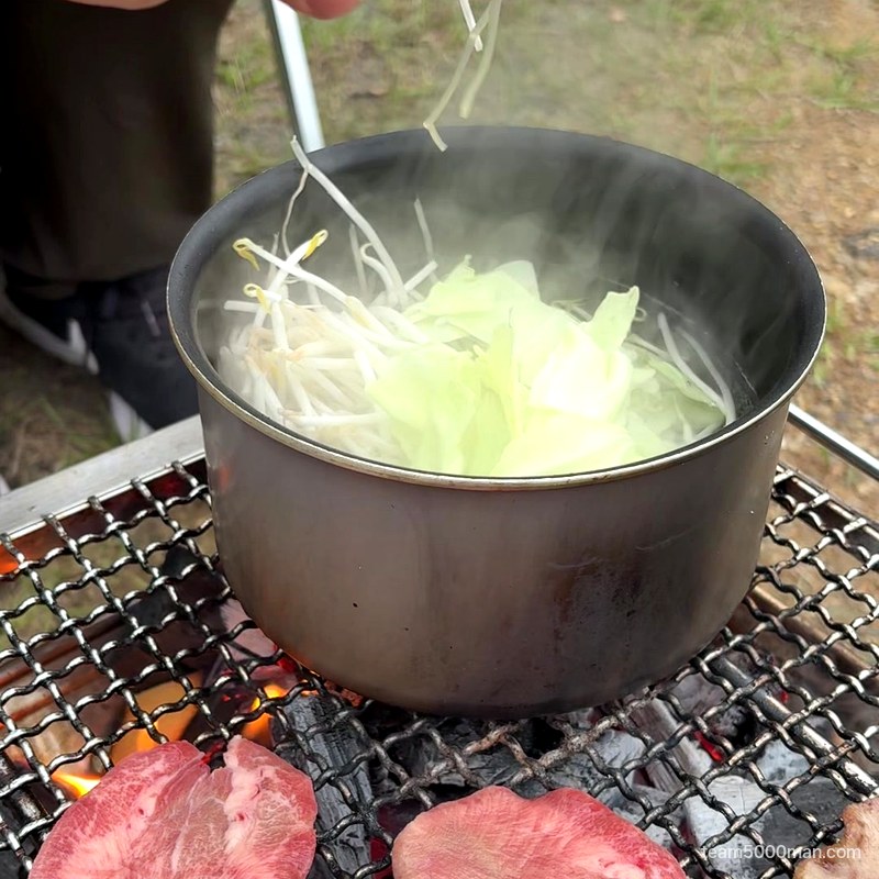 キャンプで宅麺 焚き火台の鍋にキャベツともやしを入れる