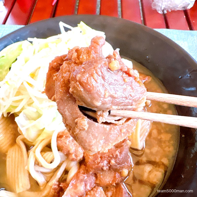 麺でる ラーメン 黒豚チャーシューを箸で持ち上げたところ