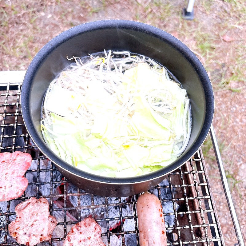 キャンプで宅麺 焚き火台でキャベツともやしを茹でている鍋